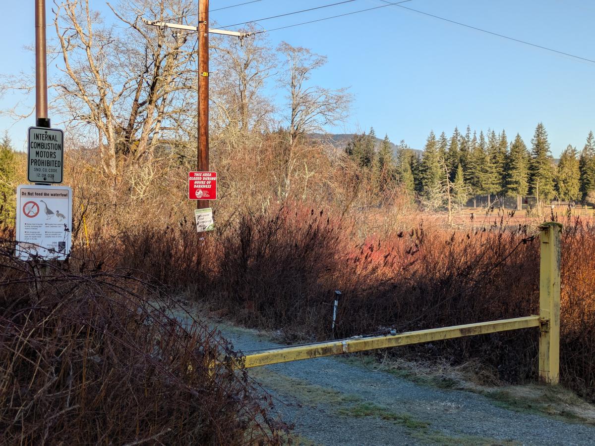 Locked yellow gate, sign requiring Discover pass