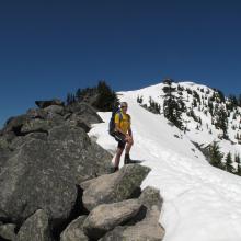 KG7EJT alternating rocks to snow.  Granite Mountain Lookout on summit, behind.