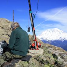 KR7W station set up.  Mast attached to old handrail post.  APRS Handy Talkie hangs from lanyard.