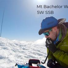 Man speaking into microphone with antenna mast in snow
